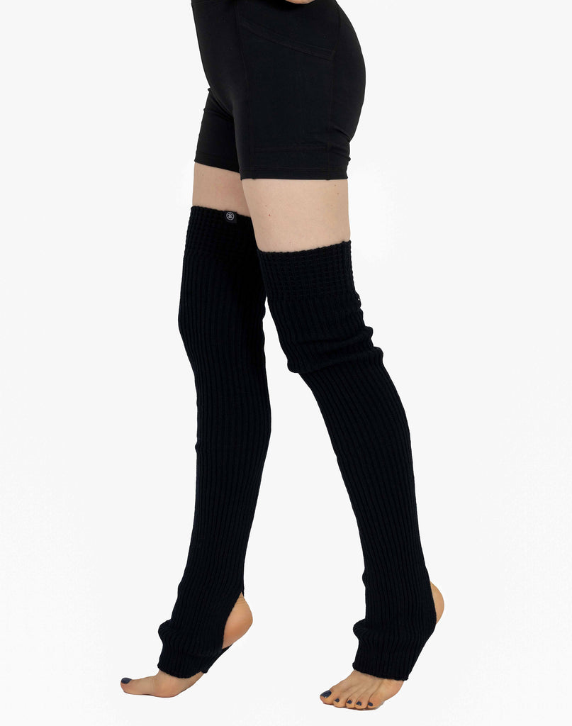 woman legs in black tight pants barefoot knees up Stock Photo